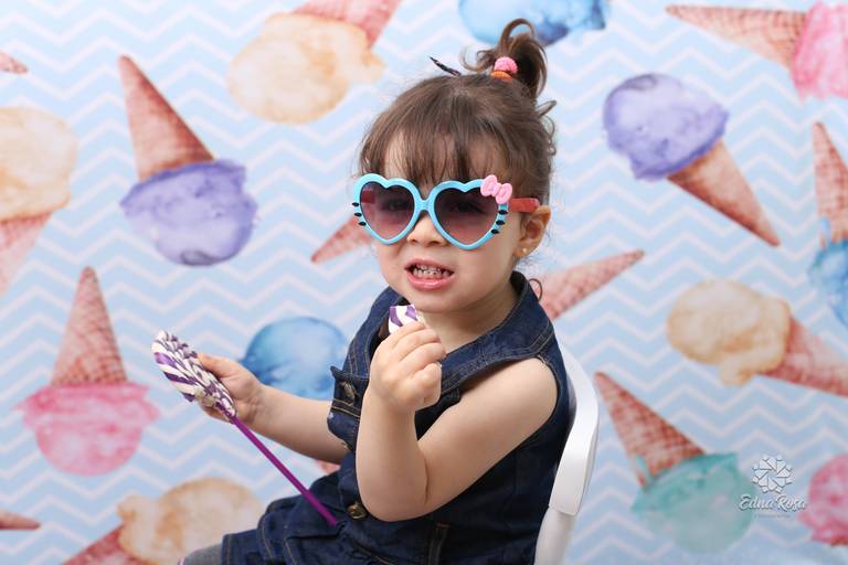 crianca posa para foto com oculos de coracao e pirulito na mao em sao bernardo do campo