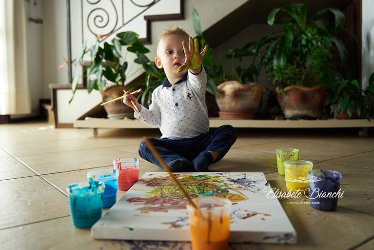Paint baby de criança em tela de pintura com tinta comestível, em ensaio infantil feito em casa, em Caxias do Sul.