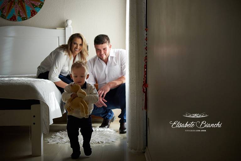 Criança fugindo do quarto dos pais, com ursinho de pelúcia nas mãos, em ensaio infantil lifestyle, em Caxias do Sul.