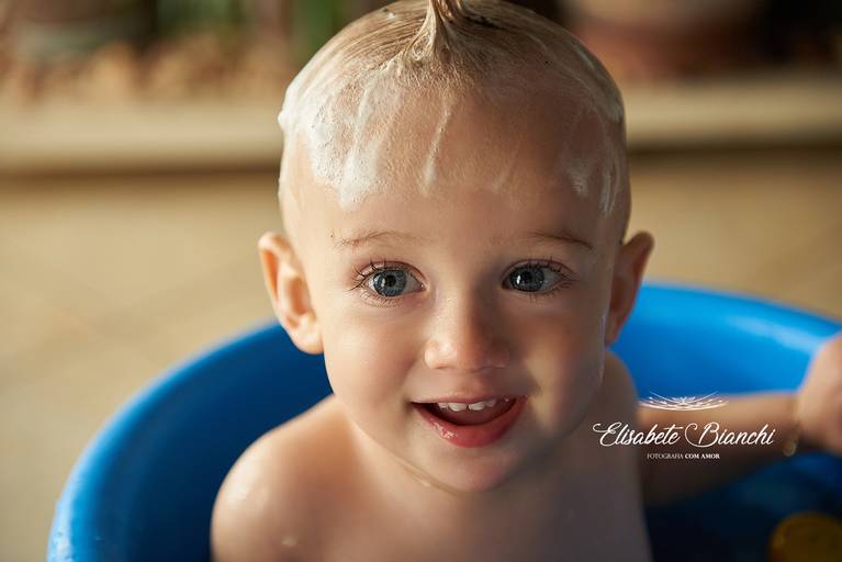 Bebê ensaboado, sorrindo no banho de ofurô, em ensaio infantil, em sua residência, em Caxias do Sul.