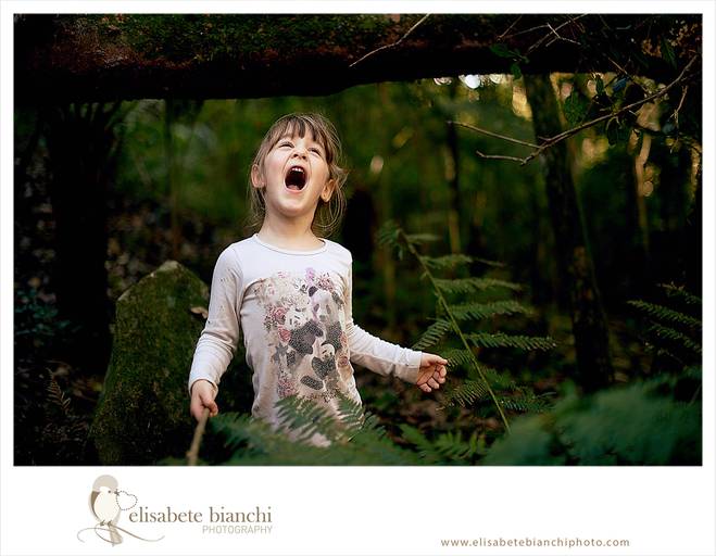 Criança com vareta na mão, gritando, em meio a mata verde, em ensaio infantil externo, entre Caxias do Sul e Farroupilha.