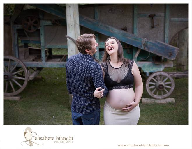 Casal conversando e rindo, o homem está de costas e a mulher está de frente e rindo. A fotografia faz parte do ensaio externo da gestação, realizado nas Casas Bonnet, no interior de Caxias do Sul. 