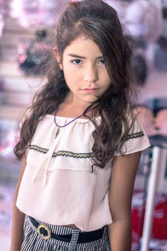 retrato infantil de garota com cabelos castanhos ondulados