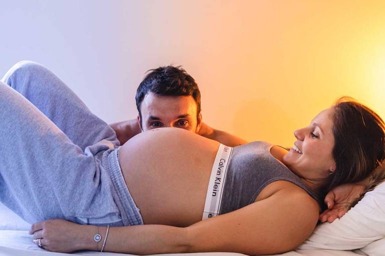 casal grávidos deitados na cama 