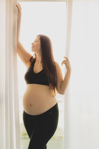 Gestante na cortina do quarto