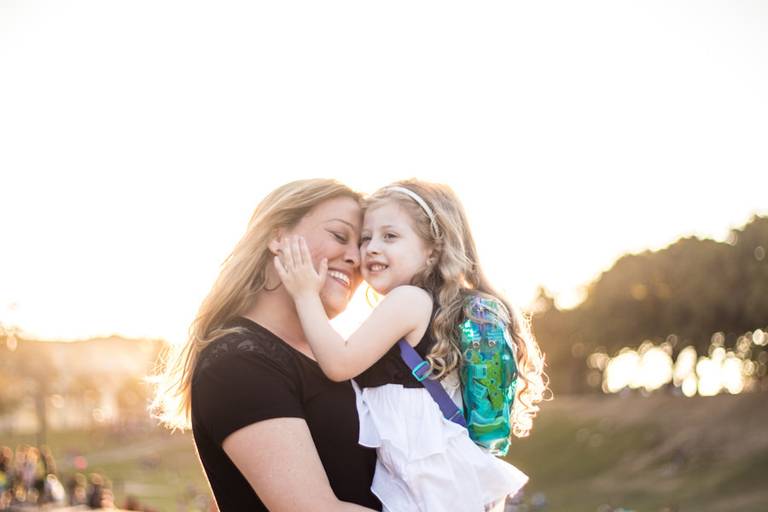 Mãe e filha se abraçando no Parque ao pôr do sol 