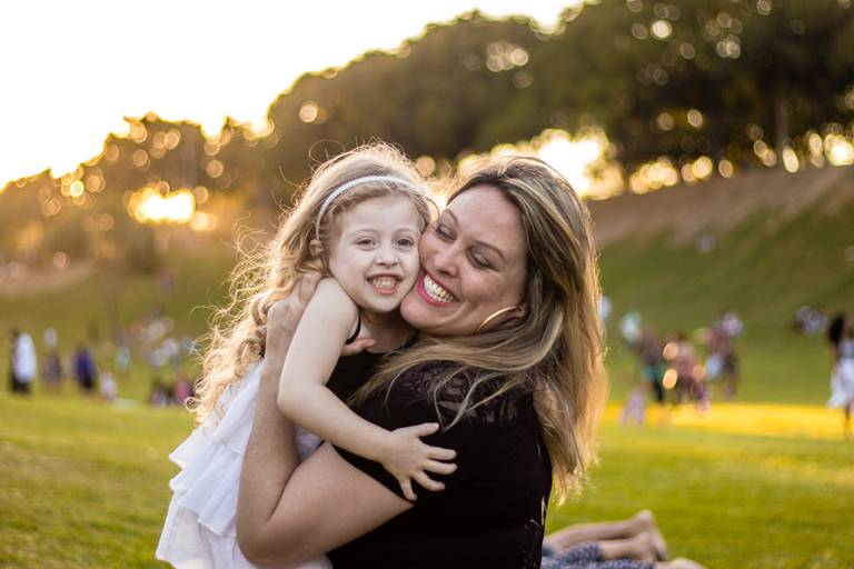 Mãe e filha se abraçando no Parque ao pôr do sol 