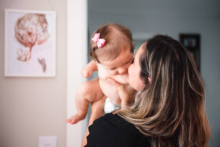 mãe dando beijo na filha 