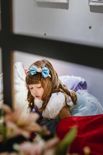 menina vestida com fantasia da Cinderela brincando no quarto
