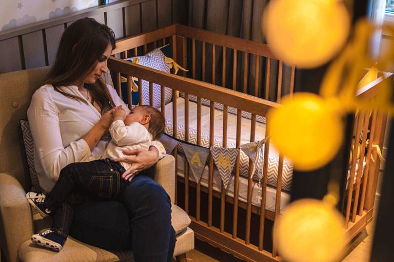 mãe amamentando bebê no quarto 
