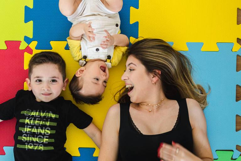 irmãos deitados no chão brincando