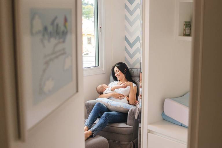  mãe e filho bebê estados na poltrona de amamentação no quarto do bebê