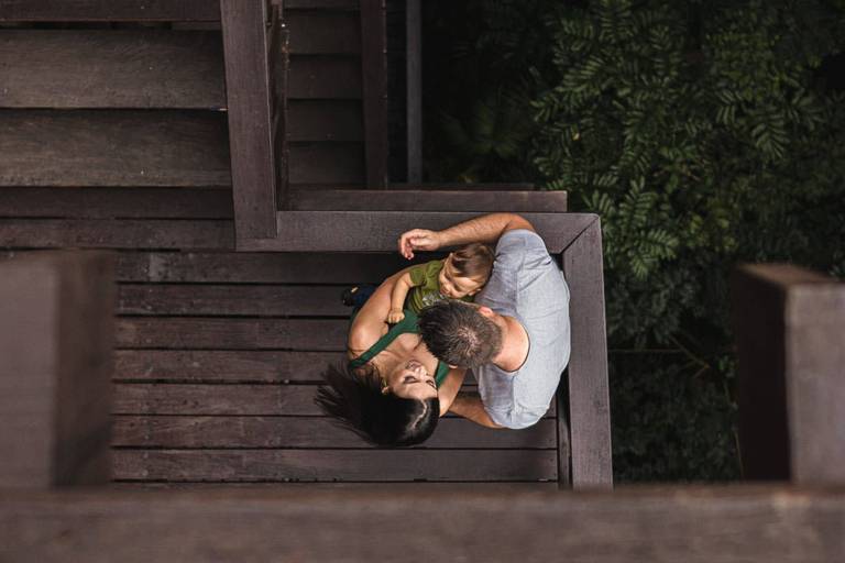 Pai e mãe com filho no colo brincando no Bosque do Alemão 