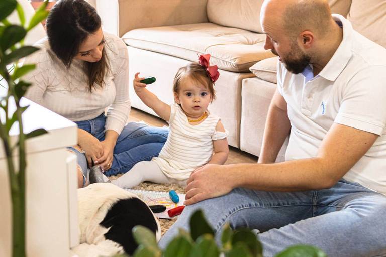 Pai, mãe e filha bebê desenhando em casa