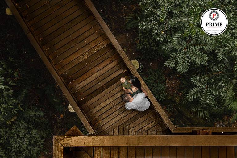 Pai e mãe com filho no colo brincando no Bosque do Alemão 