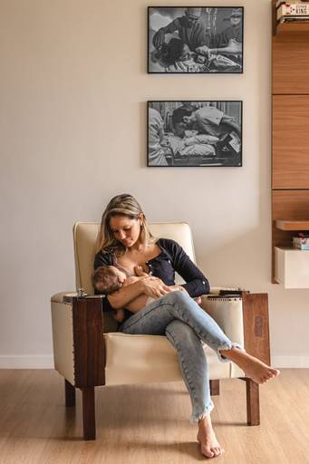 mãe amamentando na cadeira  no ensaio de newborn lifestyle