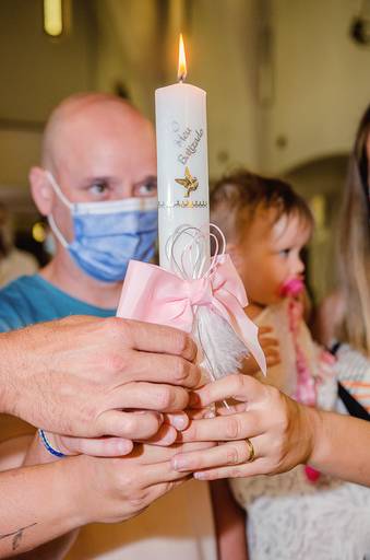 pais-segurando-vela-no-batizado-da-filha