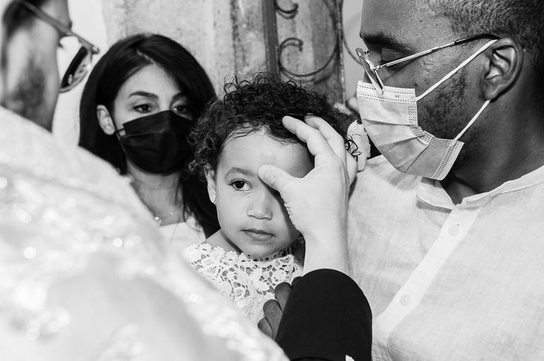 padre-fazendo-sinal-da-cruz-na-testa-de-menina-do-batizado
