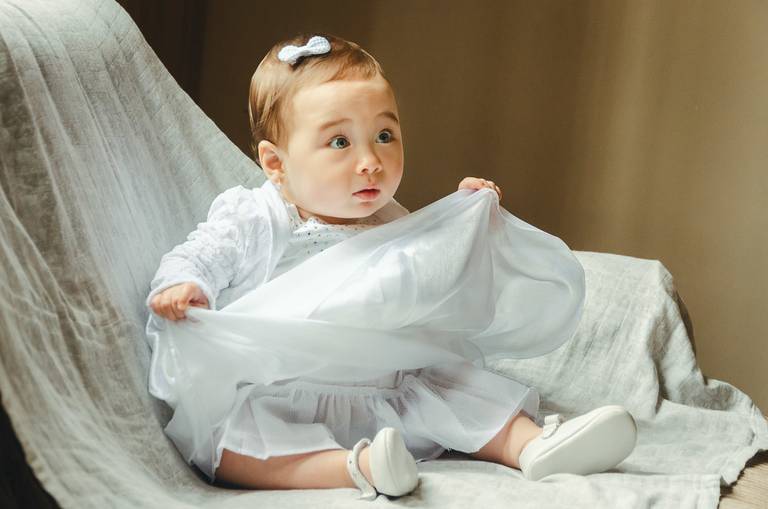 menina-segurando-vestido-no-batizado
