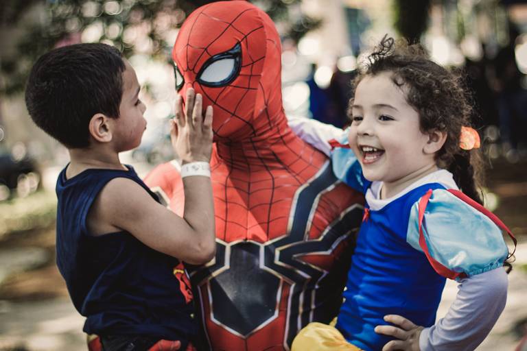 fotografia com  o homen aranha segurando uma menina e um menino em cada braço