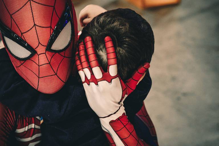 foto retrato  do homem aranha dando um abraço em uma criança