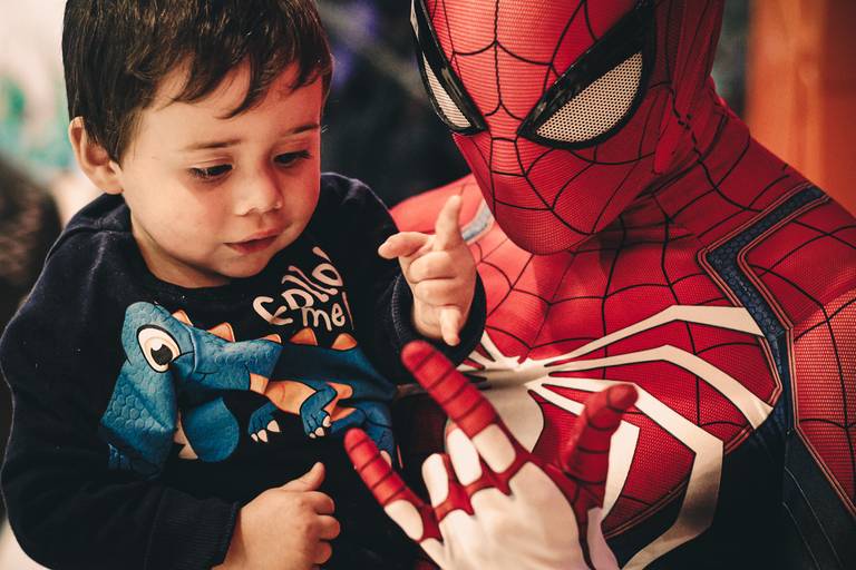 fotografia do homem arnha segurando uma criança demonstrando o seu gesto de teia