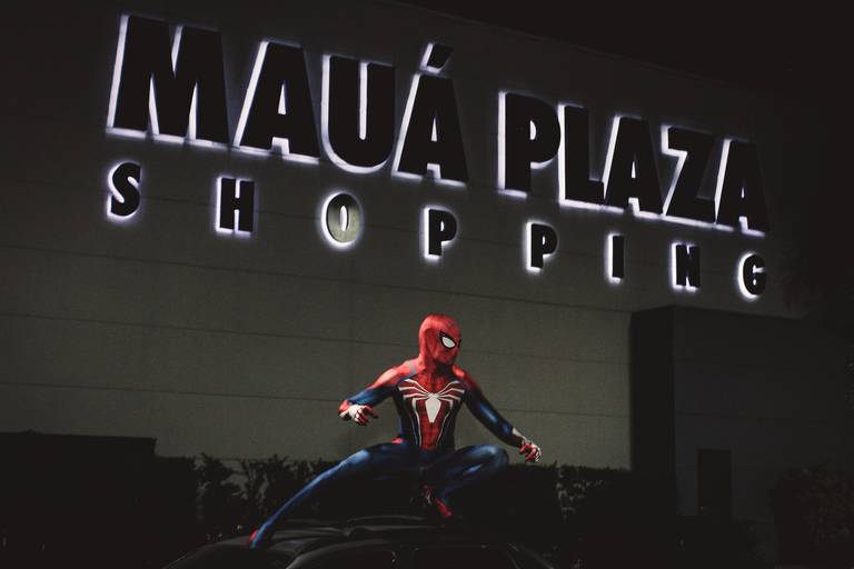 retrato do homem aranha em cima do carro com o letreiro do shopping de mauá