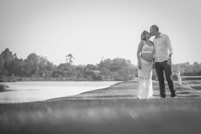 book de gestante em porto alegre e cachoeirinha casal se beijando ao lado de um lago