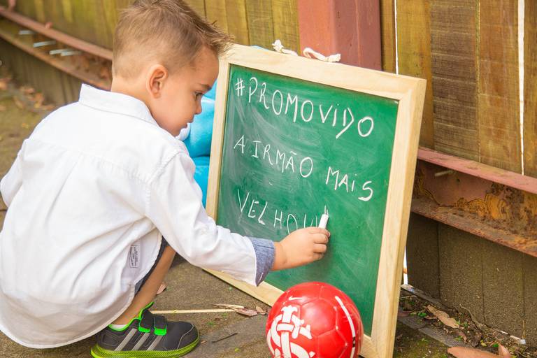 book de gestante em porto alegre e cachoeirinha filho mais velho escrevendo num quadro que foi promovido