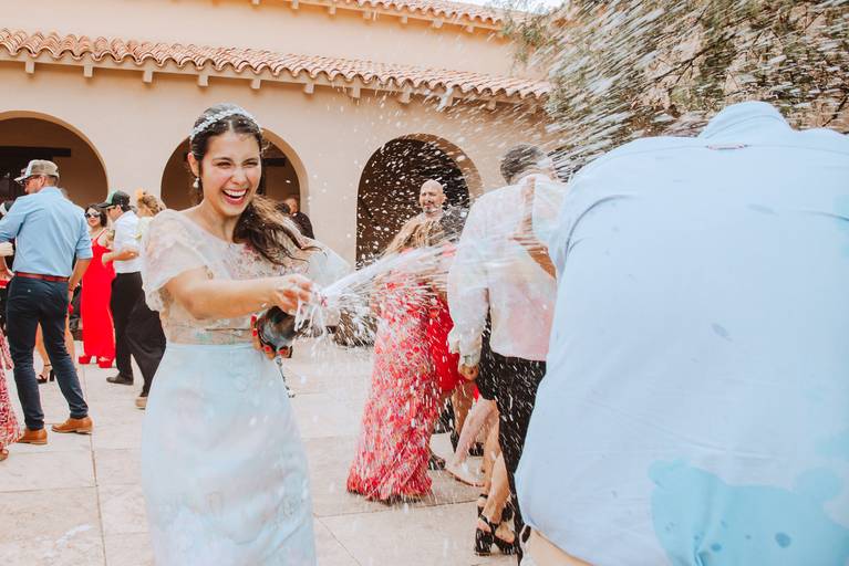 novia lanzando champaña champagne a invitado fiesta en la boda de dia al aire libre feliz carnaval alejandra ramos fotografia novias diferentes