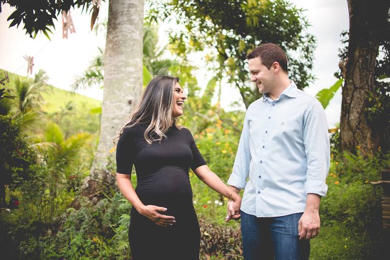 casal rindo espontaneamente na sessão de fotos de gestante