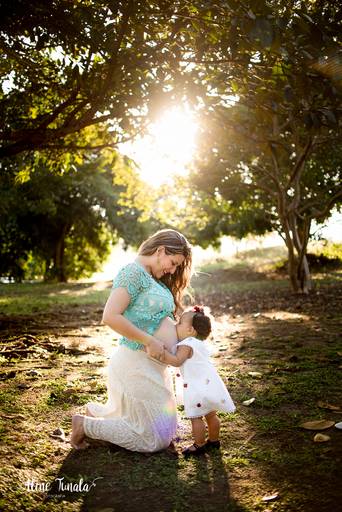 filha beijando a barriga da mãe no ensaio gestante