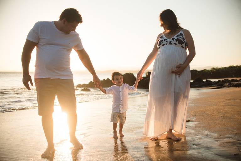 ensaio de gestante na praia com irmão participando alegre