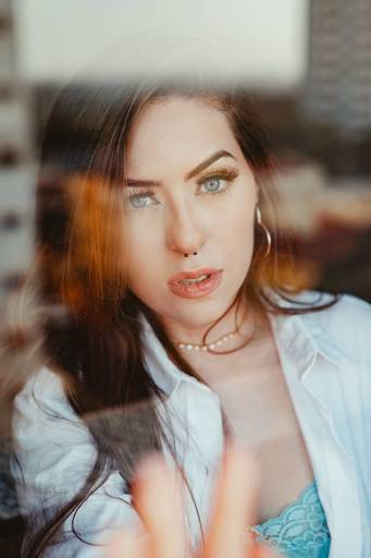 modelo olhando para a câmera atrás de uma janela de vidro