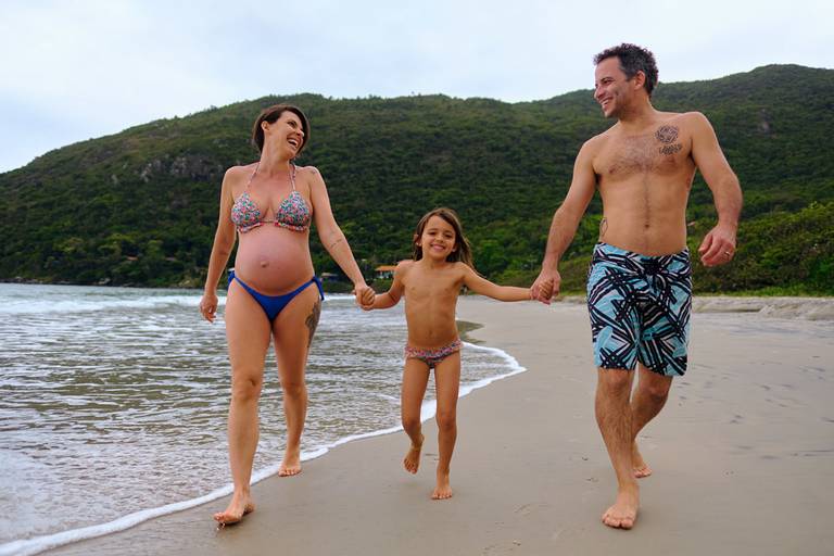 família toda a espera do caçula em ensaio gestante na praia do Matadeiro Floripa