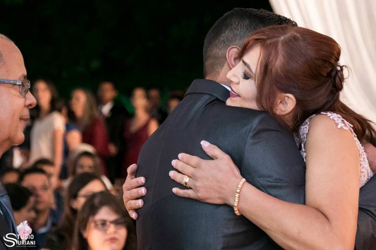 Abraço amoroso da mãe do noivo o entregando no altar em casamento ao ar livre a noite de Uberlândia 