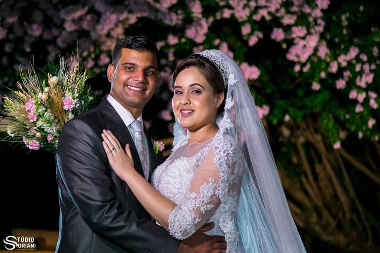Fotógrafo de casamento fazendo fotos em chácara de noite com clores rosas nas arvores