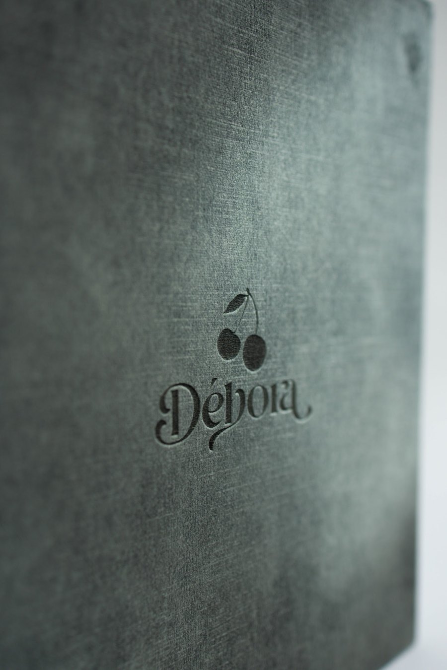 Detalhe da capa de veludo verde do álbum newborn com gravação a laser personalizada