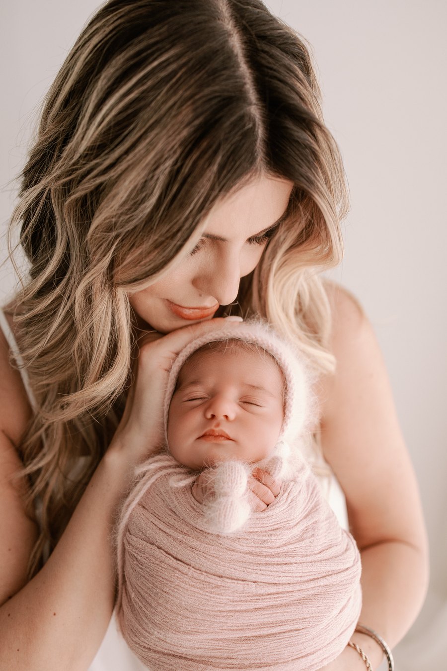 Mãe segurando o recém-nascido durante o ensaio newborn